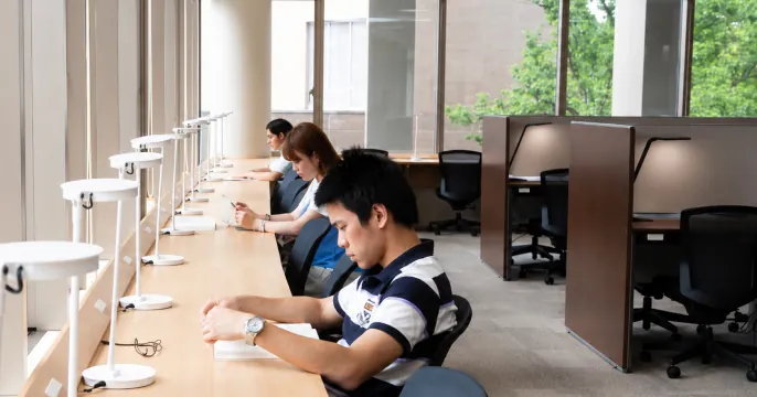 仕切り付きブースのある自習室で集中して勉強に励む学生たち