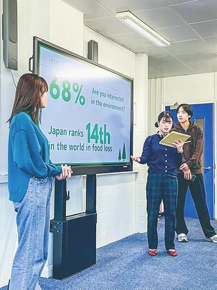 環境問題のプレゼンを行う3人の学生たち