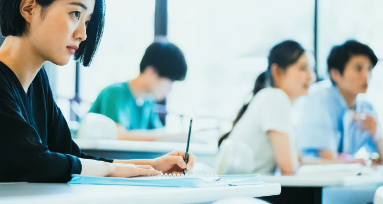 真剣に前方を見つめながら講義を受ける女性受講生