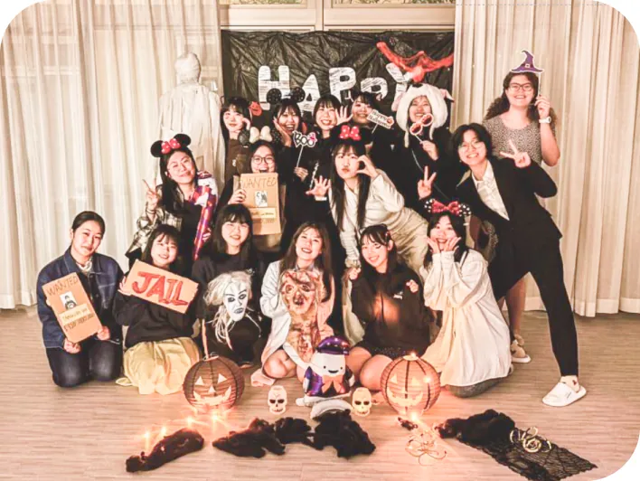 ハロウィンの仮装をして笑顔で集まり、記念撮影をする学生たち