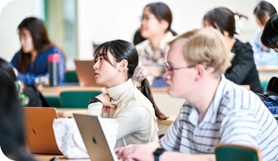 ノートパソコンを開き講義に真剣に取り組む学生たち