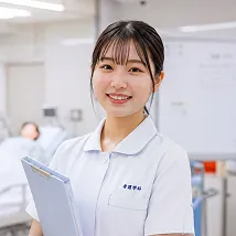 白衣を着て微笑む女子学生