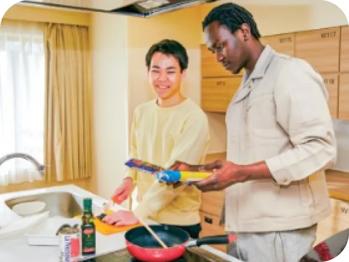 寮のキッチンで調理の準備をする留学生と日本人学生