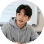 真剣に授業を聞く眼鏡の男子学生