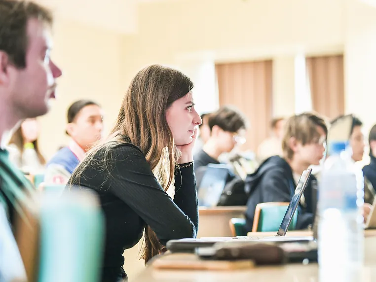 講義を熱心に聴講するロングヘアの女子学生