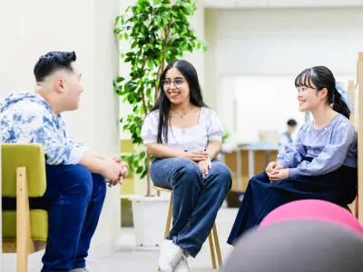 室内で笑顔で談笑する多様な学生たち